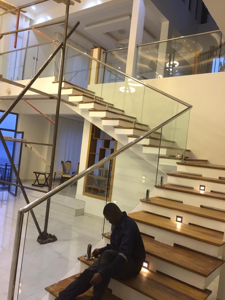 Glass and stainless steel staircase railing installation in a luxury interior