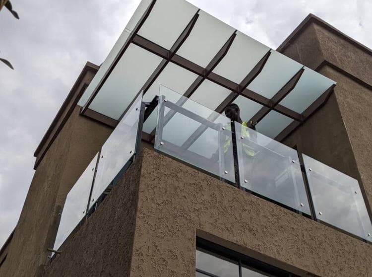 Glass balustrade and canopy installation on a commercial building facade