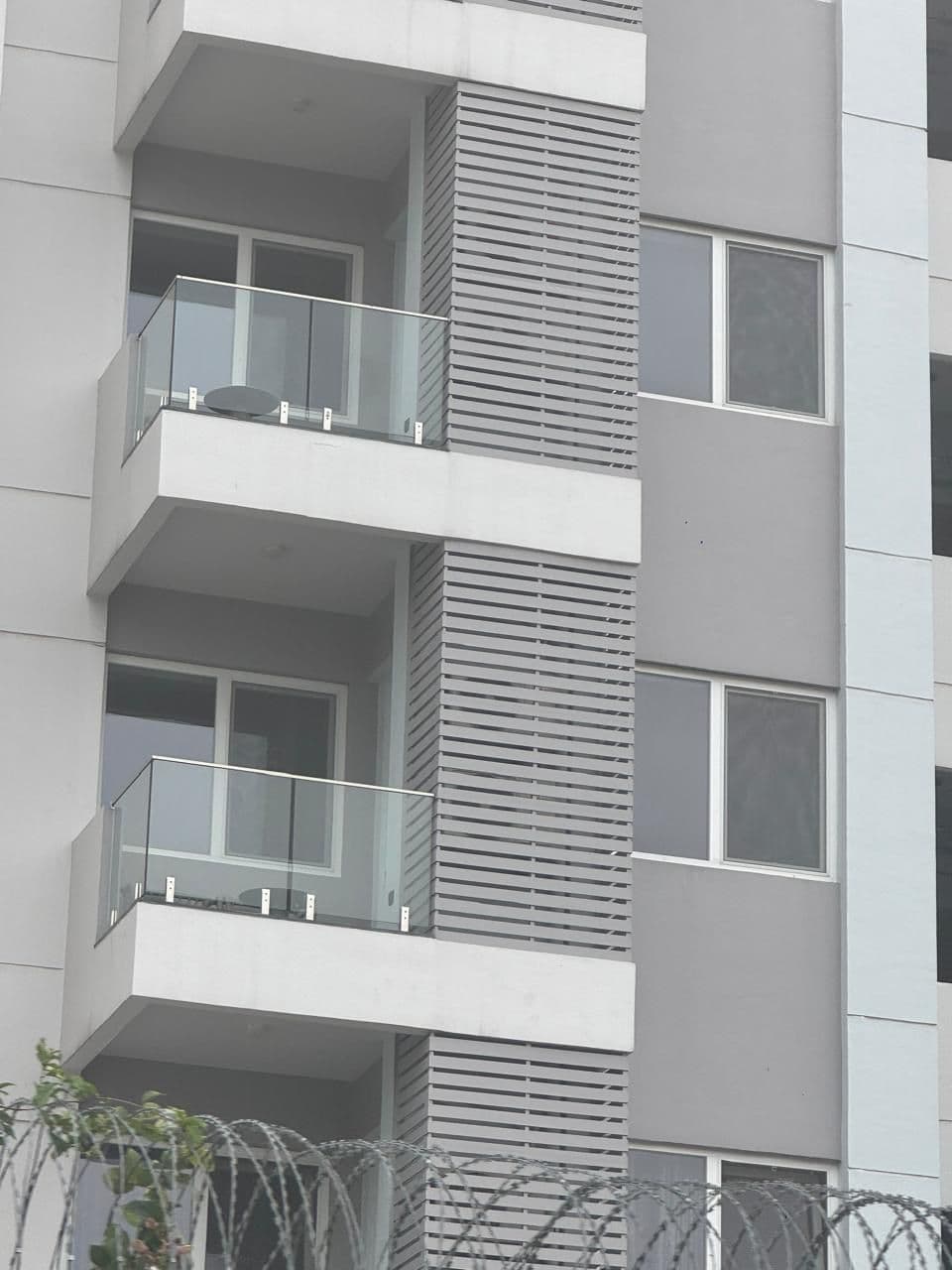 Glass balcony railings with stainless steel fittings on a modern apartment block